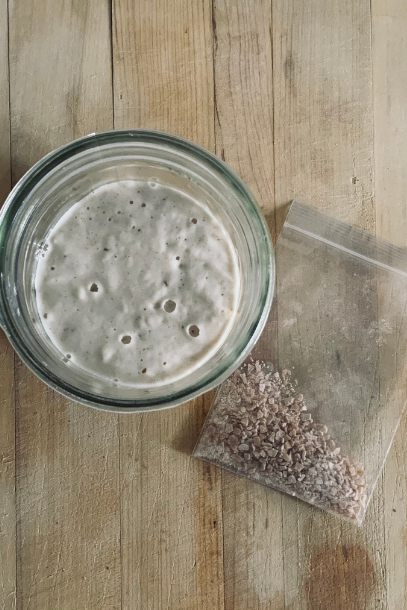 Mason jar of rehydrated sourdough starter and small bag of dehydrated sourdough starter